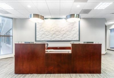 Professional reception area with a dark wood front desk and a decorative textured wall panel.