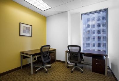 Two-person private office with a yellow feature wall and large window.