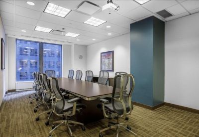 Modern conference room with a large wooden table and views of the city.