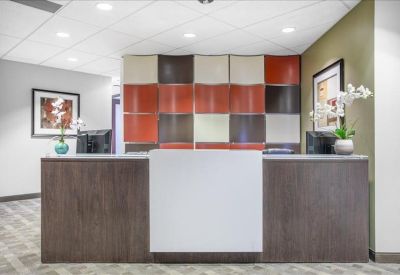 Modern reception desk with wood paneling and a vibrant multi-colored geometric backdrop.