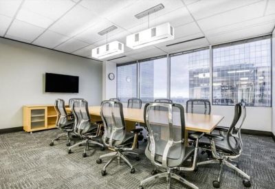 Meeting room with a large wooden table, mesh chairs, and floor-to-ceiling windows.