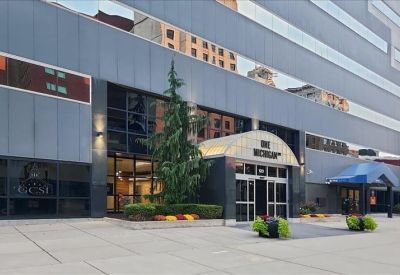 Spacious private office with a large desk and a small circular meeting table.