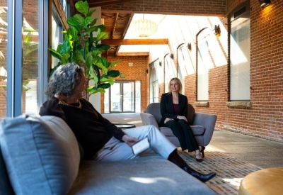 Sunlit communal lounge with brick walls and comfortable seating.