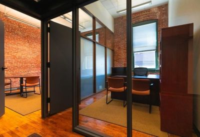 Private office suite with a wooden desk and brick accent wall.