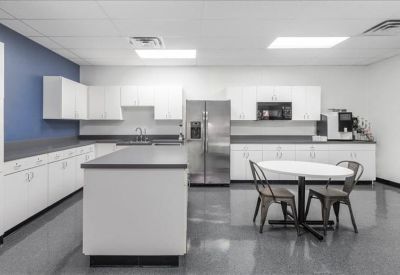 Large communal kitchen and break area with blue accent wall and dining table.