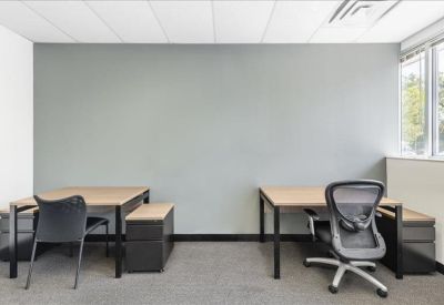 Bright internal office suite with two desks and ergonomic chairs.