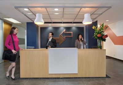 Professional reception area with a wooden front desk and floral arrangement.