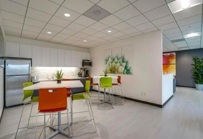Breakroom kitchen area with modern cabinetry and colorful high-top seating.