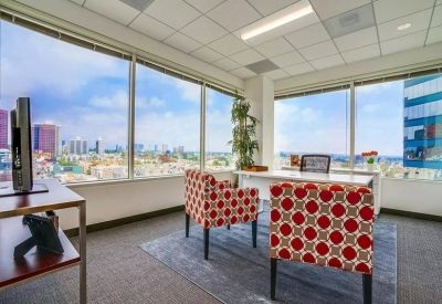 Private corner office with patterned armchairs and panoramic city views.