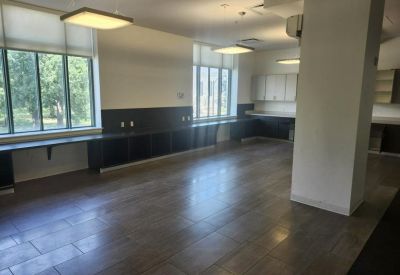 Long communal counter with integrated storage under large bright windows.