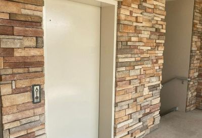 Elevator entrance surrounded by a decorative multi-toned stacked stone wall.