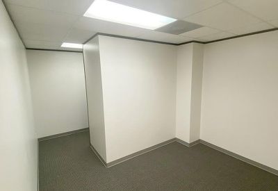 Spacious private office suite with neutral walls and grey carpet.
