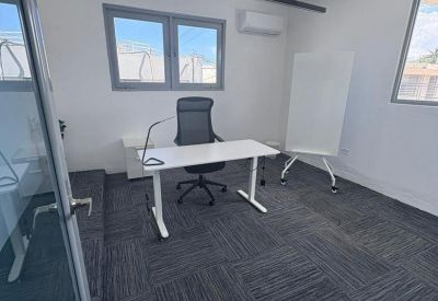 Spacious private office at 126 Calle Marginal South, Hato Rey with white desk, ergonomic chair and whiteboard.