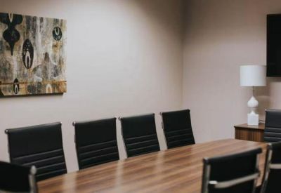 Executive boardroom with dark leather chairs and abstract wall art.