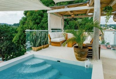 Sun-shaded rooftop terrace featuring a small plunge pool and lounge area.
