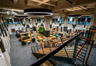 Multi-level atrium with a grand staircase, circular lights, and varied seating.