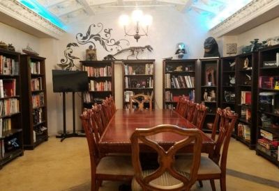 Professional meeting room at 1308, North San Fernando Road featuring a long wooden table and floor-to-ceiling bookshelves.