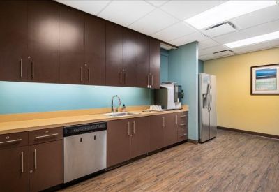 Modern breakroom kitchen with dark wood cabinetry and a stainless steel dishwasher.