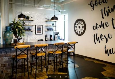 Stylized breakroom with brick accents, bar seating, and a motivational wall mural.