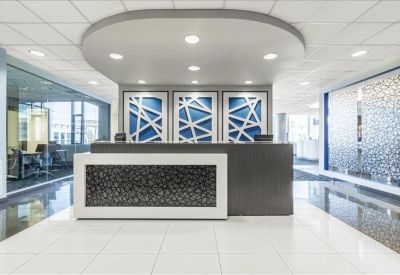 Elegant reception area with a dark stone front desk and blue geometric wall art.
