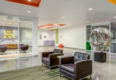 Modern lobby and reception area featuring dark leather armchairs and a large silver sculpture.