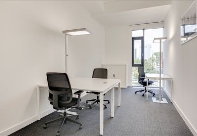Private two-person office suite with white desks and minimalist lighting.