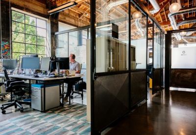 Modern office suite featuring glass partitions and natural light.