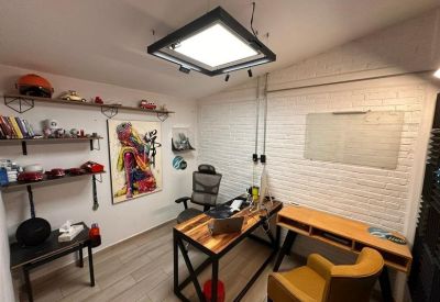 Bright private office with a wooden desk, yellow armchair, and unique square pendant lighting.