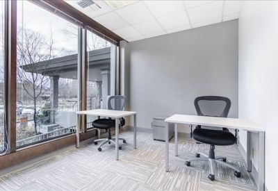 Private office featuring two white desks and large windows overlooking the grounds.