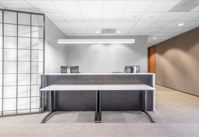 Minimalist reception area with a long white front desk and a decorative wall partition.