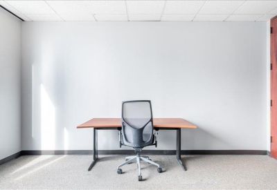 Bright private office suite with a simple desk and ergonomic chair.