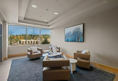 Sunlit lounge area with modern leather armchairs and scenic window views.