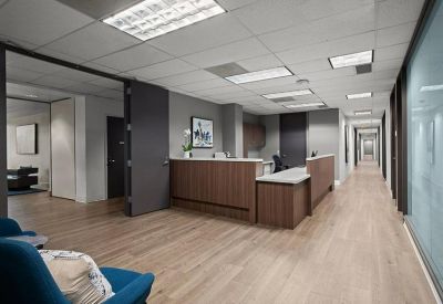 Professional reception desk with wood paneling and a long bright corridor.
