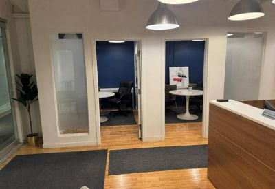 View from a wood-paneled reception area into two separate small meeting rooms.