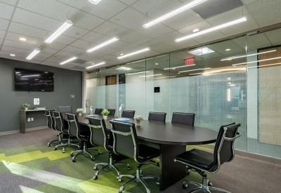 Conference room with a dark wood table and a colorful patterned rug.