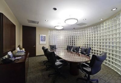 Executive conference room with a large oval table and a frosted glass-block feature wall.