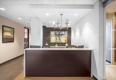 Branded reception area with a dark wood desk under a stylish chandelier.