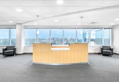 Bright reception area with a wooden front desk and a blue feature wall.