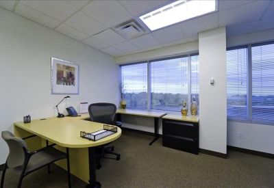 Private office with a large L-shaped desk and expansive window views.