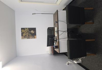 Private office with a dual-monitor desk setup and modern artwork.