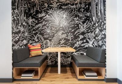 Cozy dining booth set against a black and white botanical mural.