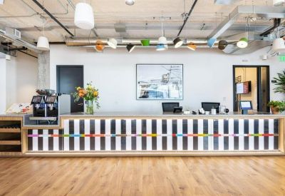 Bright reception desk with colorful pendant lights and a graphic pattern on the front.