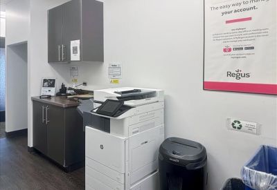 Copy and print station featuring a large multifunction printer and storage cabinets.