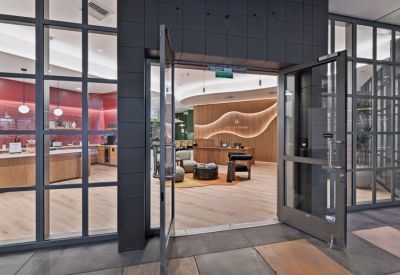 Glass entrance doors leading into a modern reception and lobby area.