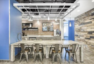 Communal kitchen and dining area featuring a marble-topped table and industrial lighting.