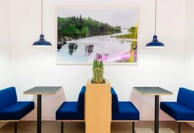 Modern dining booths with blue cushions and matching pendant lights below a scenic mural.