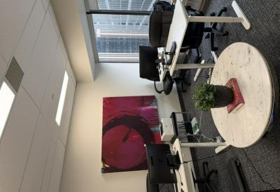 Modern workspace with height-adjustable desks and vibrant abstract wall art.