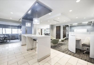 Modern communal break area with high-top tables and bright white finishes.