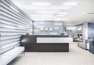 Minimalist reception area with a dark grey front desk and linear wall lighting.
