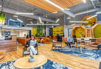 Spacious communal lounge with colorful seating and unique honeycomb-shaped quiet pods.